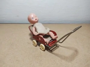 Starý plechový kočárek s panenkou